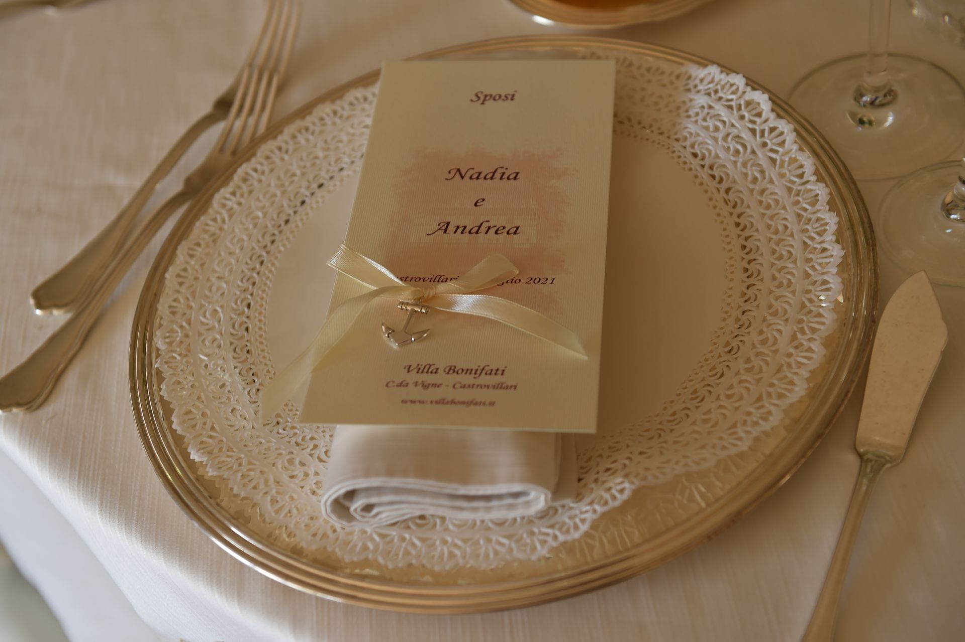 Un piatto d'argento con un tovagliolo e sopra un menu