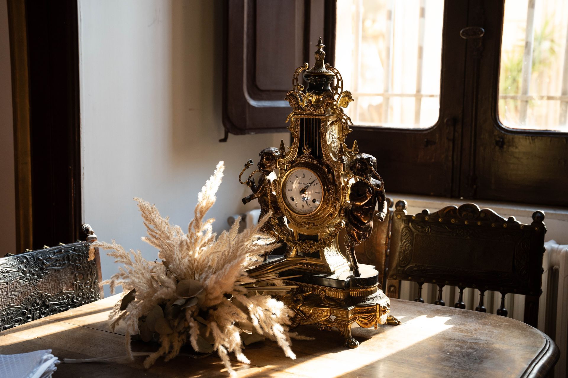 Un orologio è appoggiato su un tavolo di legno vicino a una finestra.