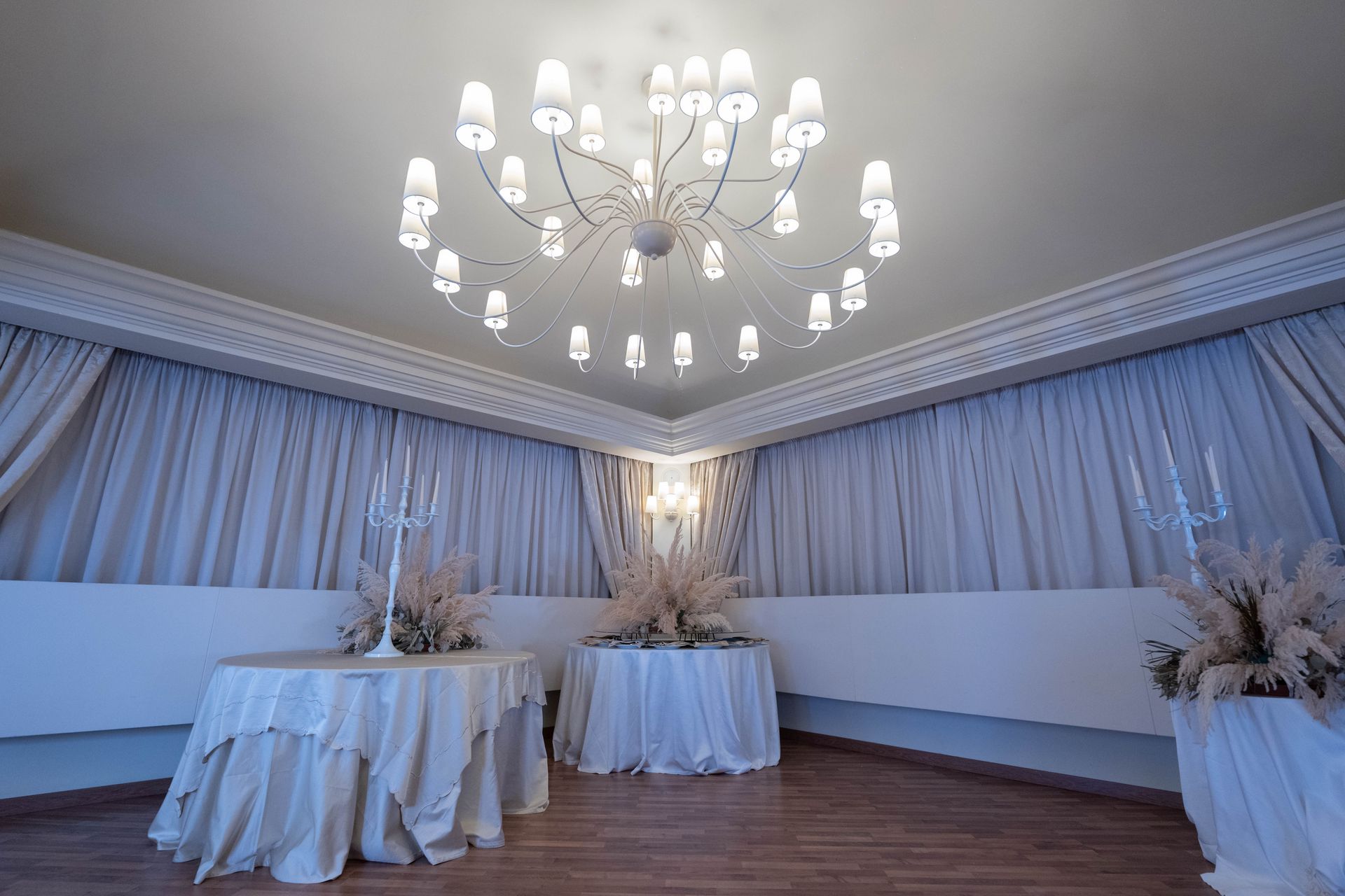 Una stanza con tavoli e un lampadario al soffitto.