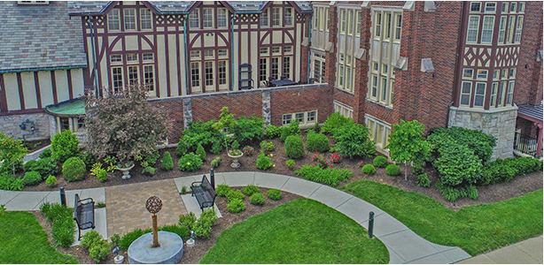 An aerial view of a large brick building with a walkway leading to it