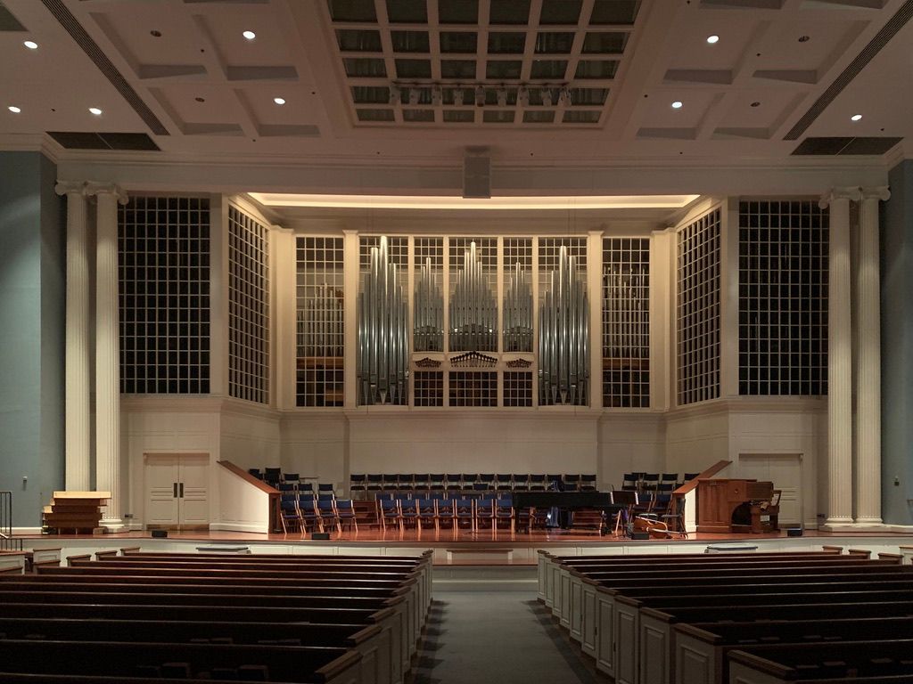 An empty church with a large organ in the background