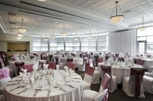 A large room with tables and chairs set up for a wedding reception.