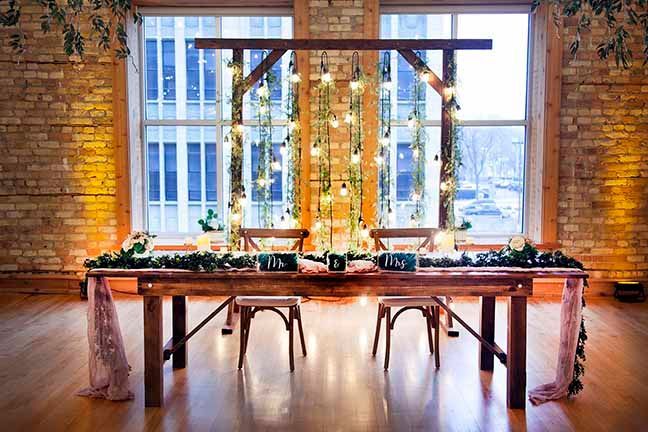 A long wooden table with chairs in front of a large window.