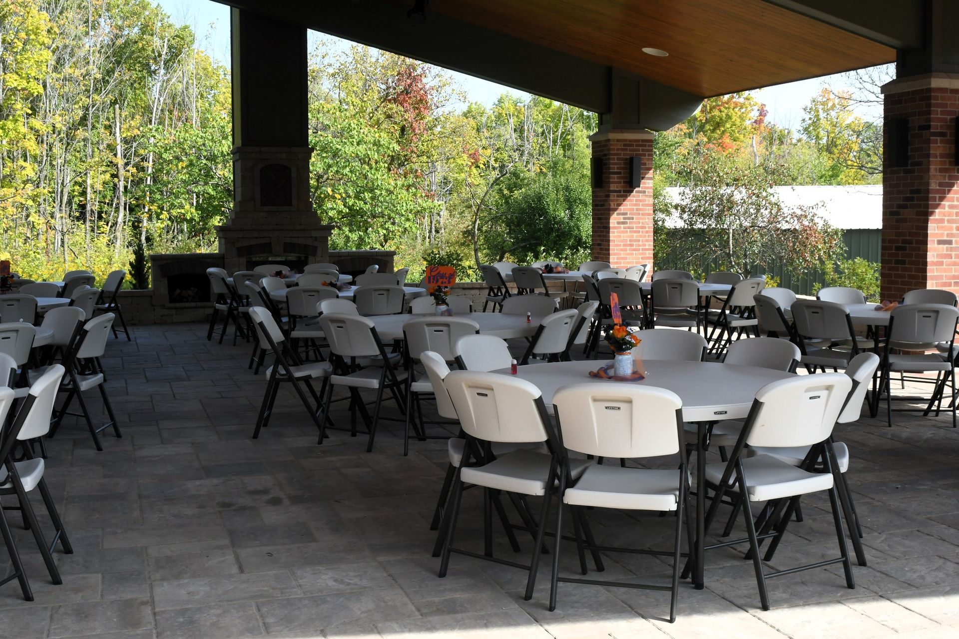 A patio with tables and chairs under a canopy