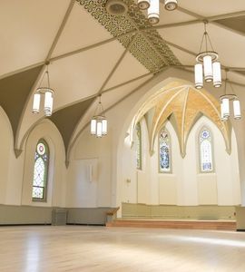 An empty church with arched ceilings and stained glass windows.