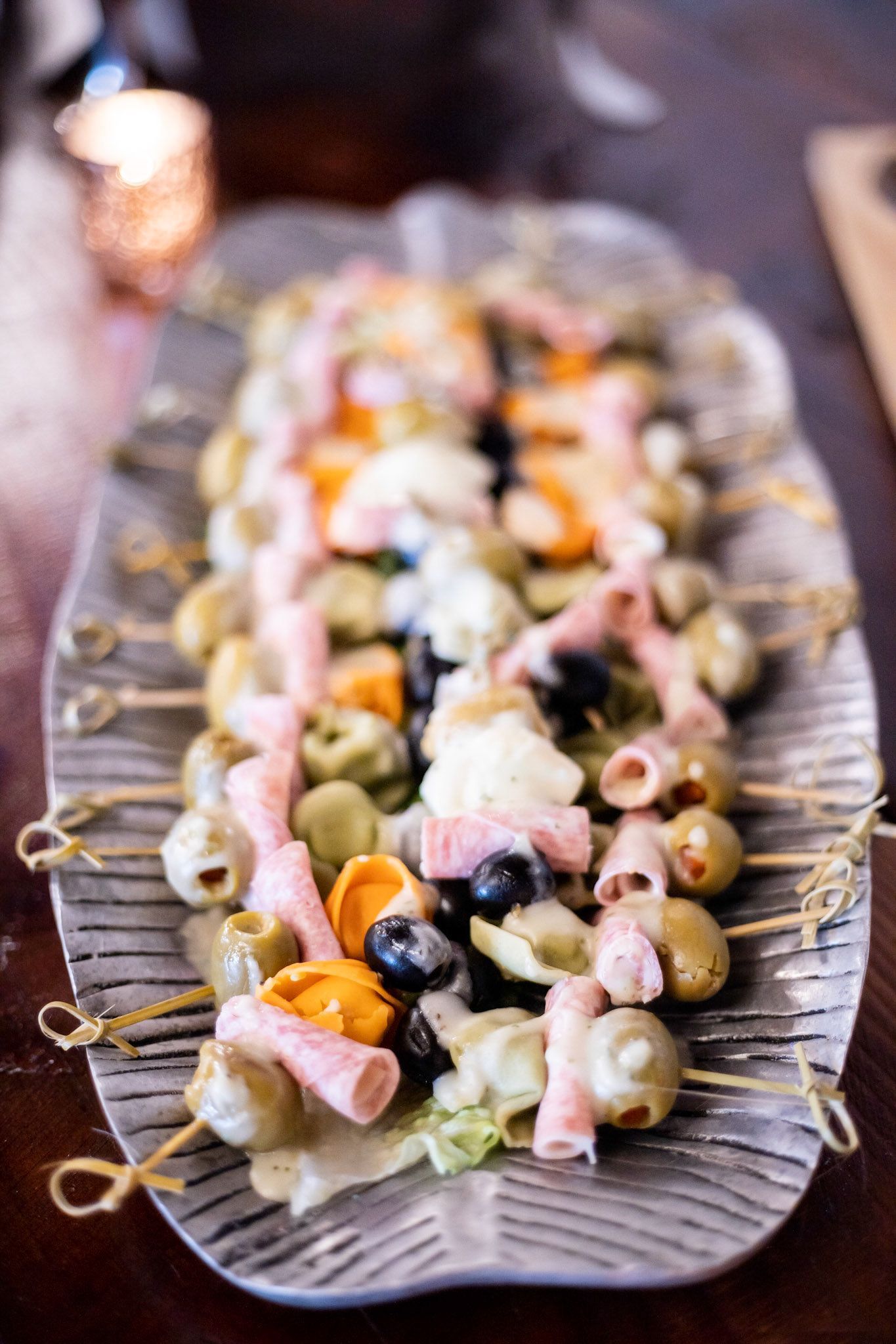 A tray of food on skewers on a table.