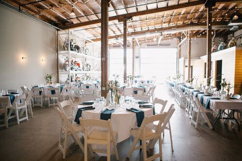 A large room with tables and chairs set up for a wedding reception.
