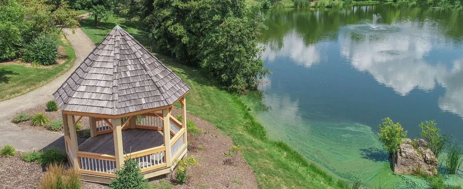 An aerial view of a gazebo next to a lake.