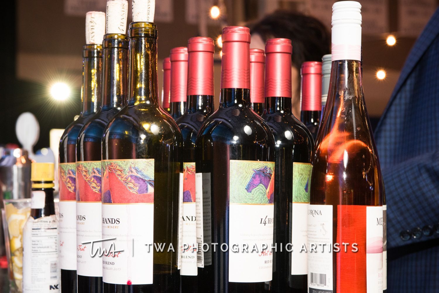 A row of bottles of wine are lined up on a table.