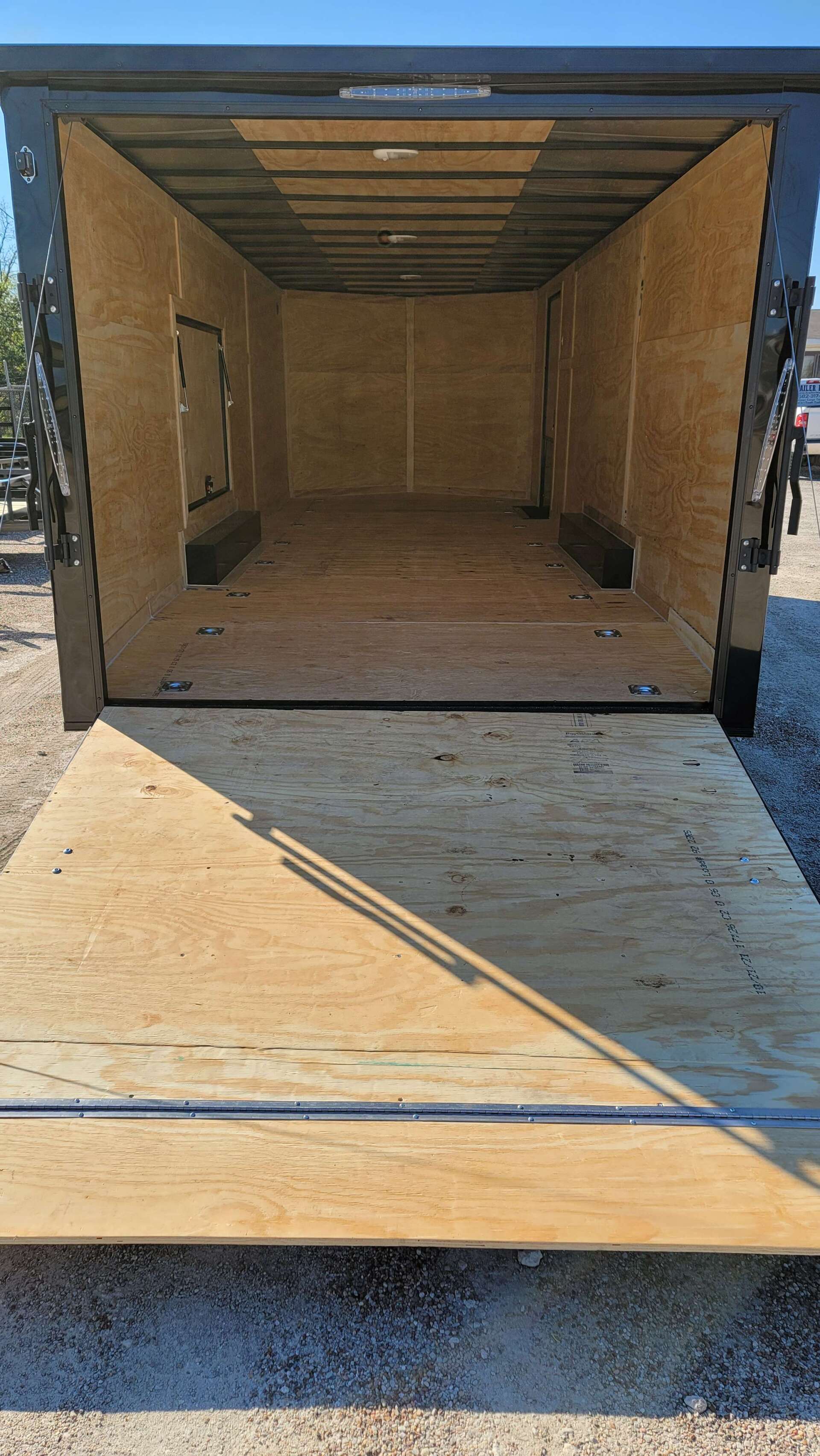 The back of an empty trailer with the door open.