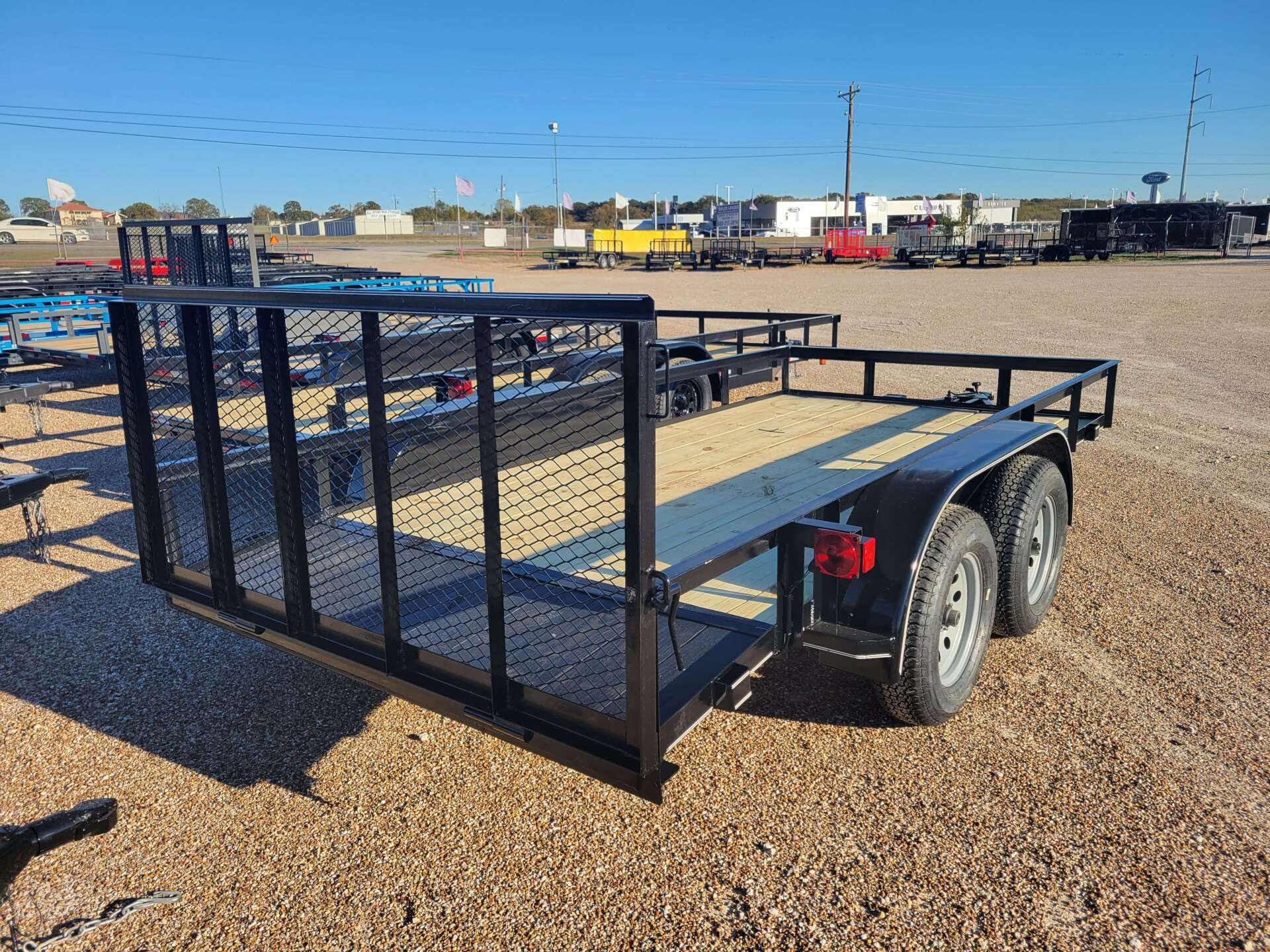 A trailer is sitting on top of a gravel field.