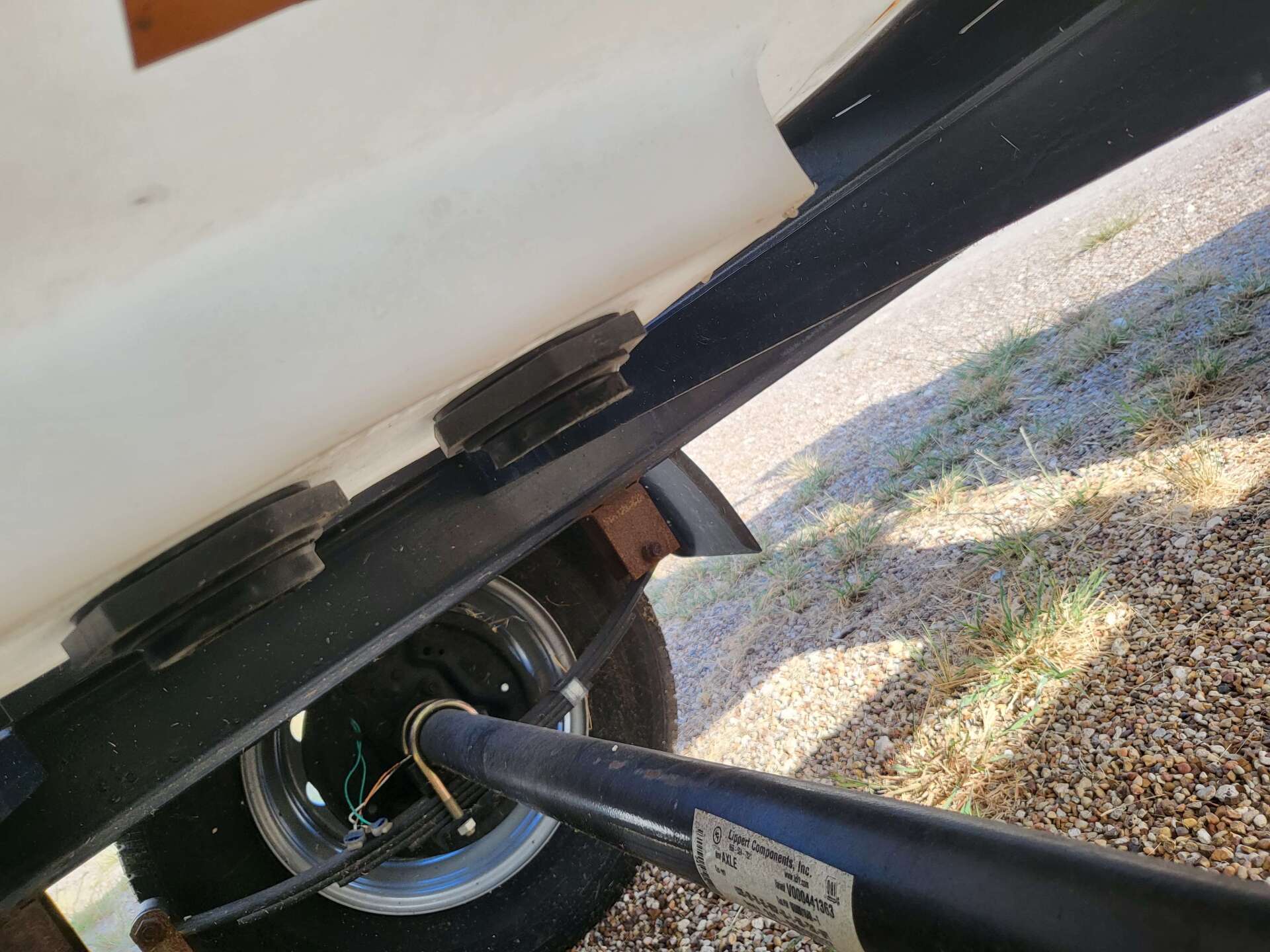 A close up of a trailer on a gravel road.