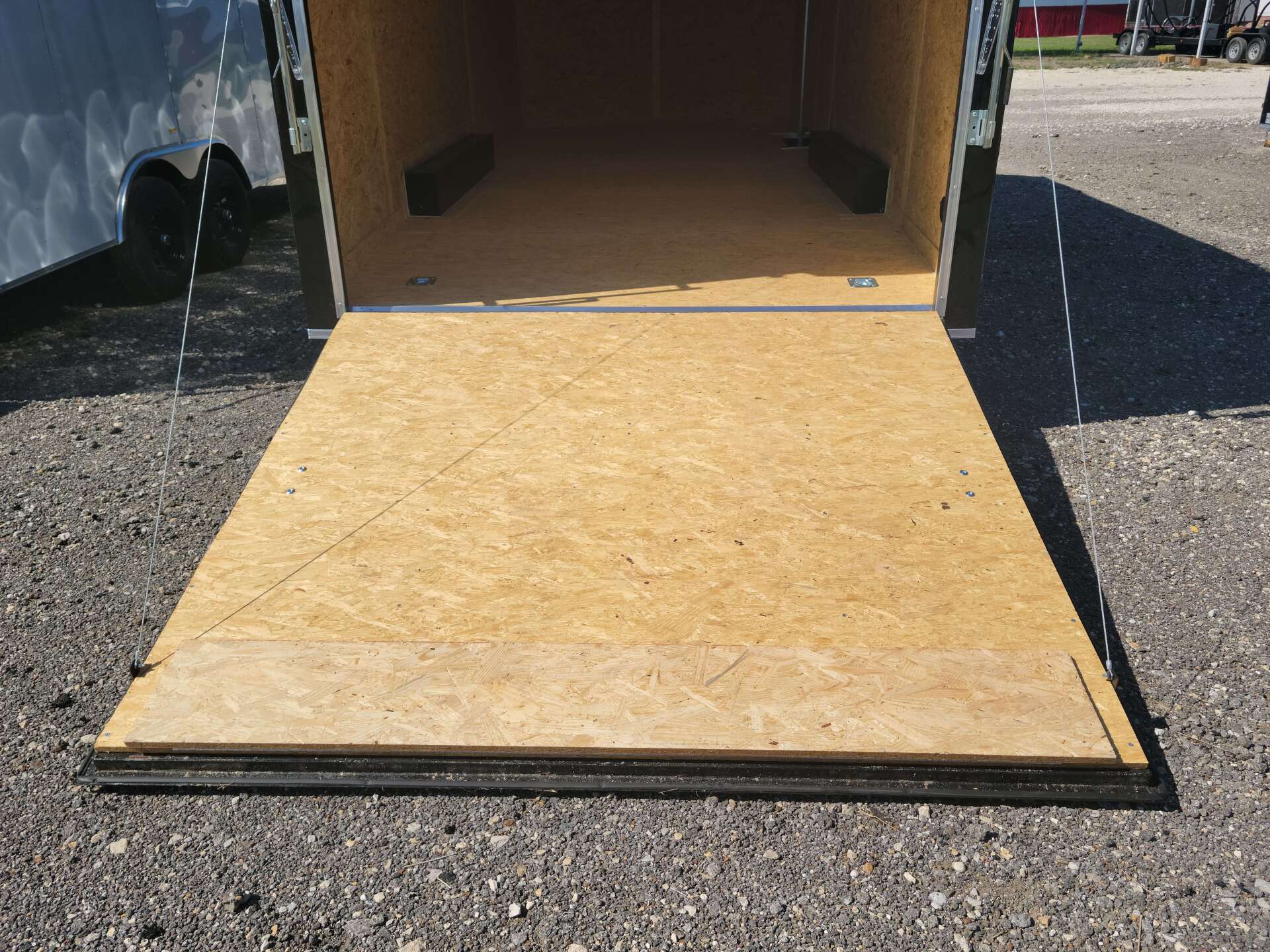 The back of a trailer with the door open and a wooden floor.