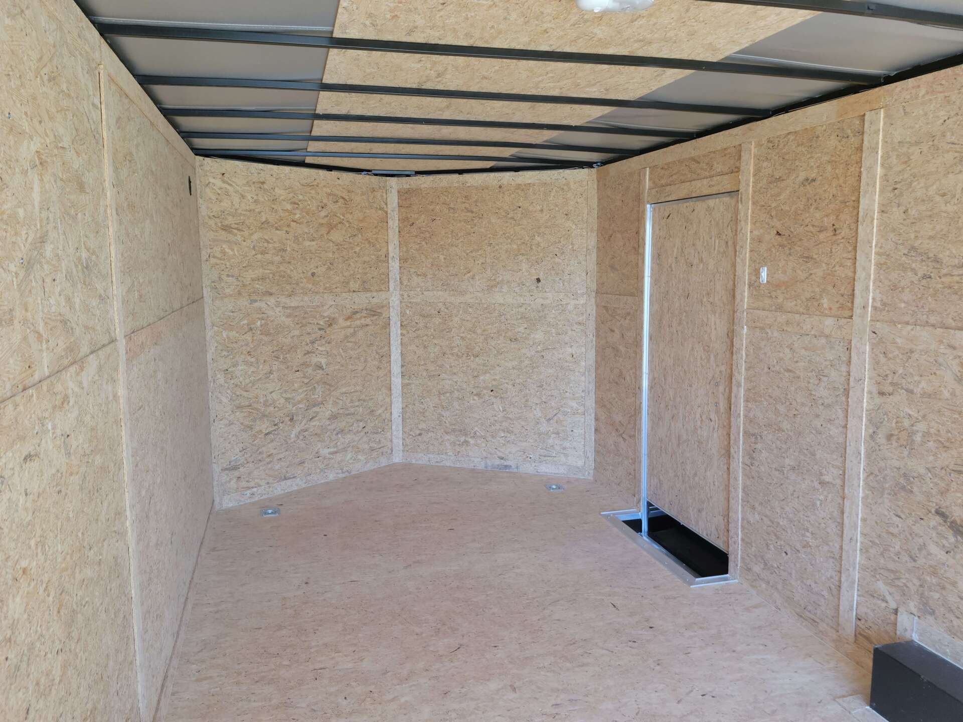 A large empty room with wooden walls and a metal ceiling.