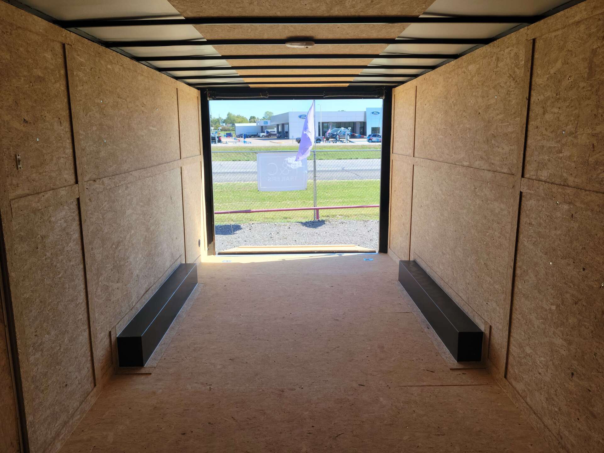 The inside of an empty trailer with the door open