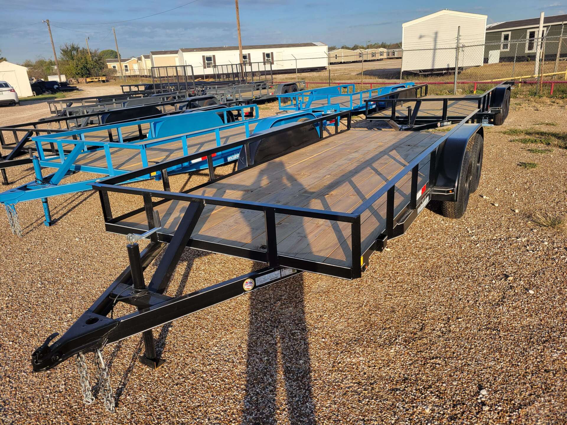 A trailer is sitting on top of a gravel lot.