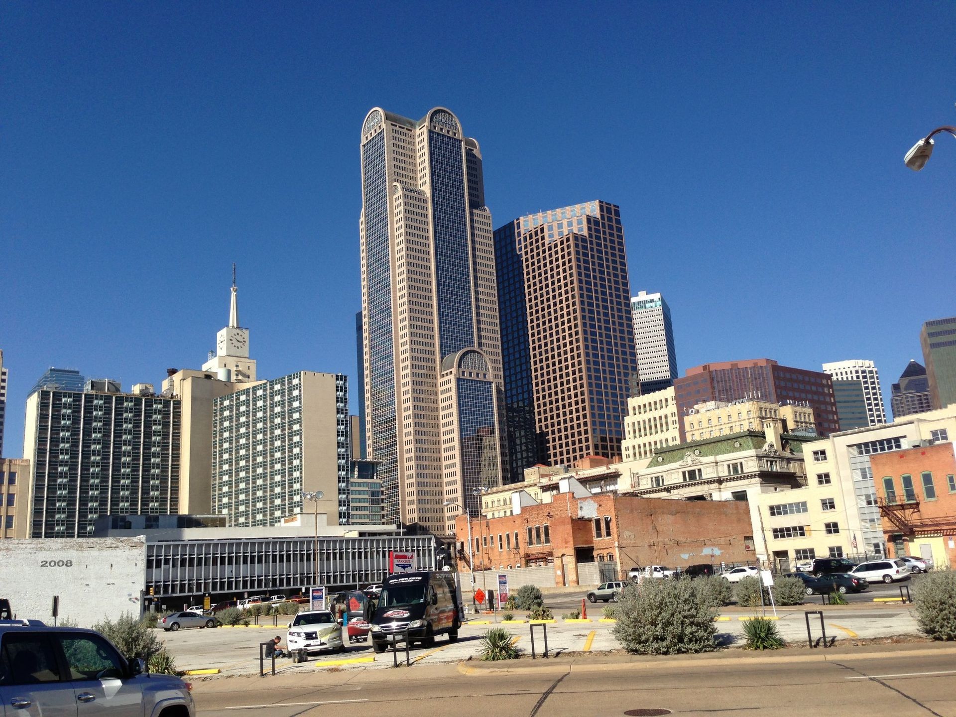 A car is parked in front of a city skyline