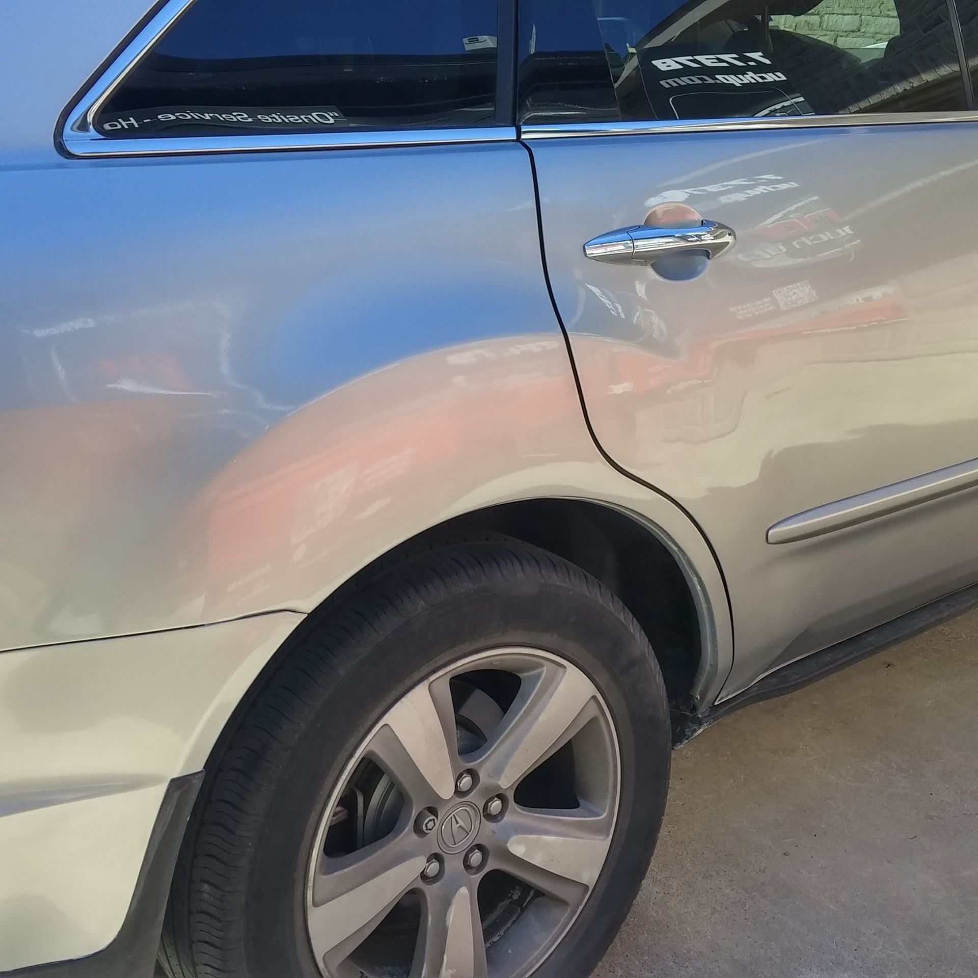 A silver car is parked on the side of the road