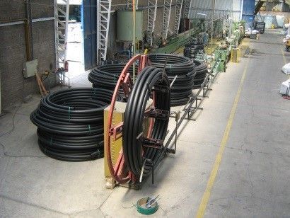 Un montón de tubos están apilados uno encima del otro en un almacén.