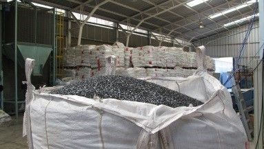 Una bolsa grande llena de grava se encuentra en un almacén.