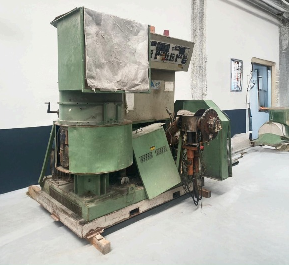 Maquina industrial verde sobre palet de madera, con cuadro de mandos y revestimientos.