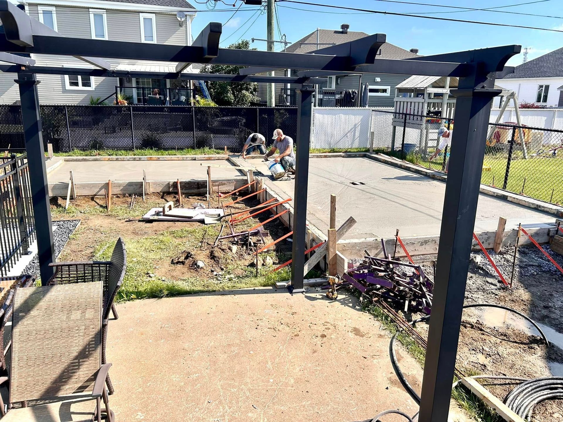 Une pergola est en cours de construction dans l'arrière-cour d'une maison.