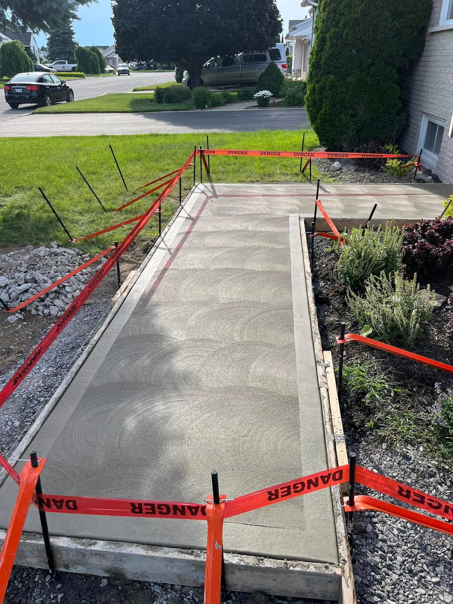 Une passerelle en béton est en cours de construction devant une maison.