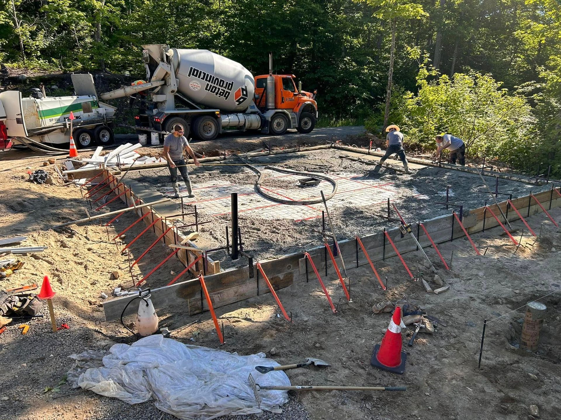 Un camion malaxeur à béton verse du béton sur un chantier de construction.