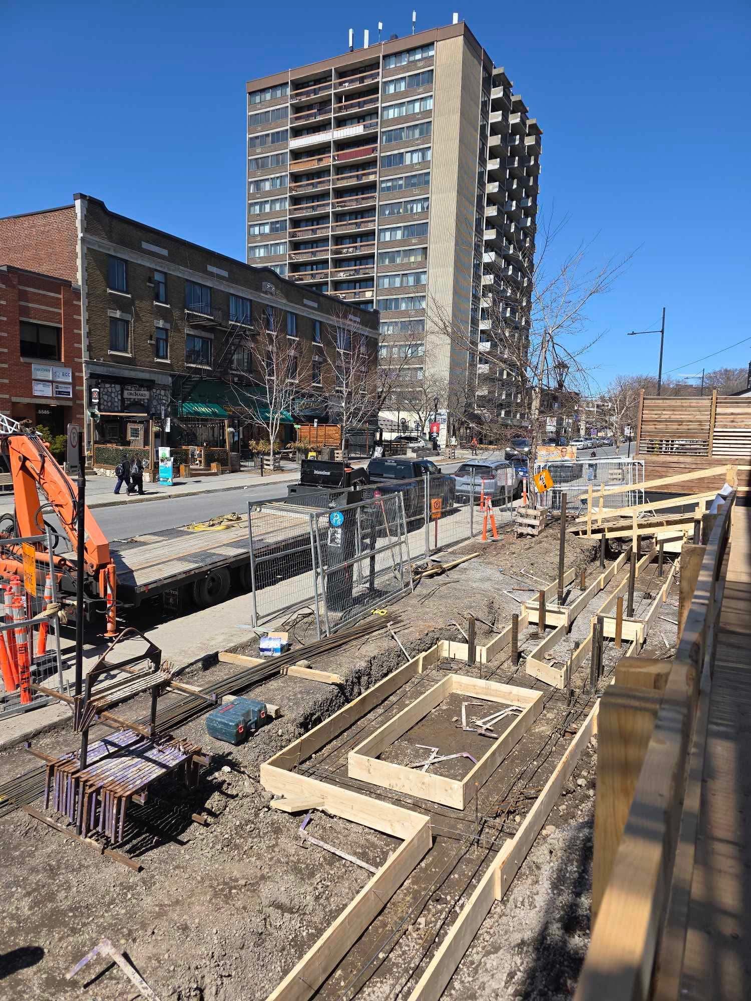 Un chantier de construction avec un grand bâtiment en arrière-plan.