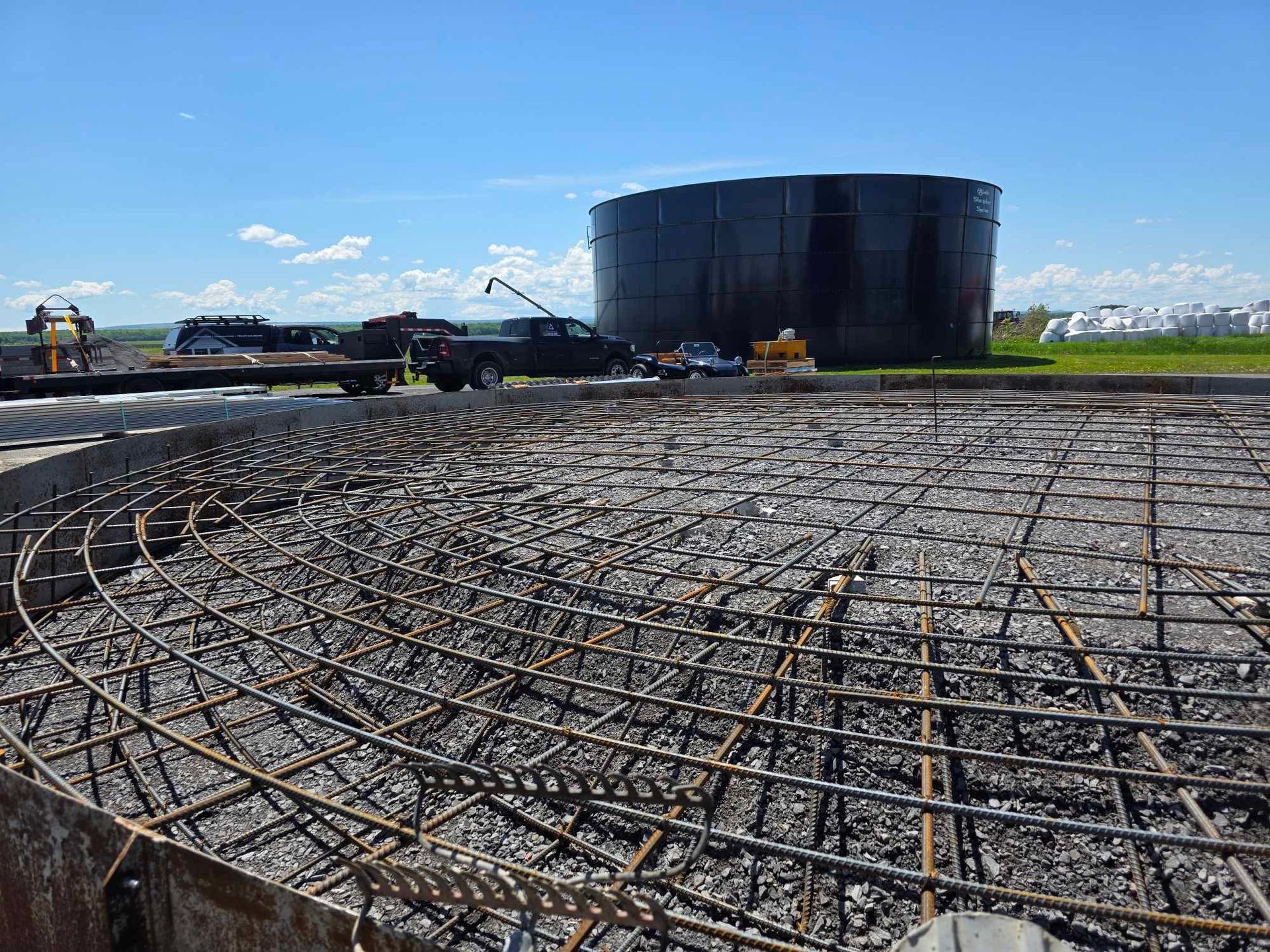 Un grand réservoir est en cours de construction sur un chantier.