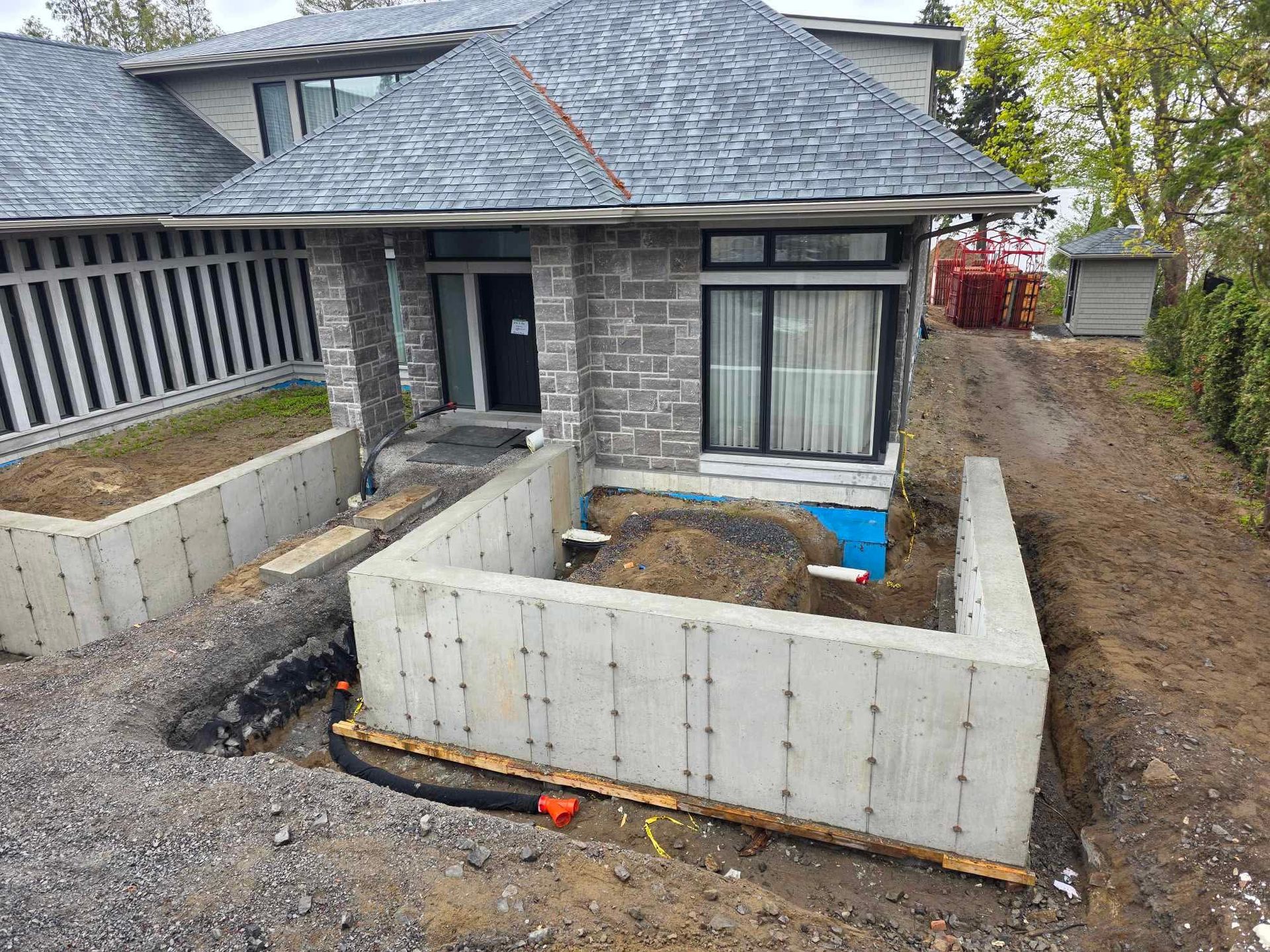 Une maison en construction avec un mur en béton devant.