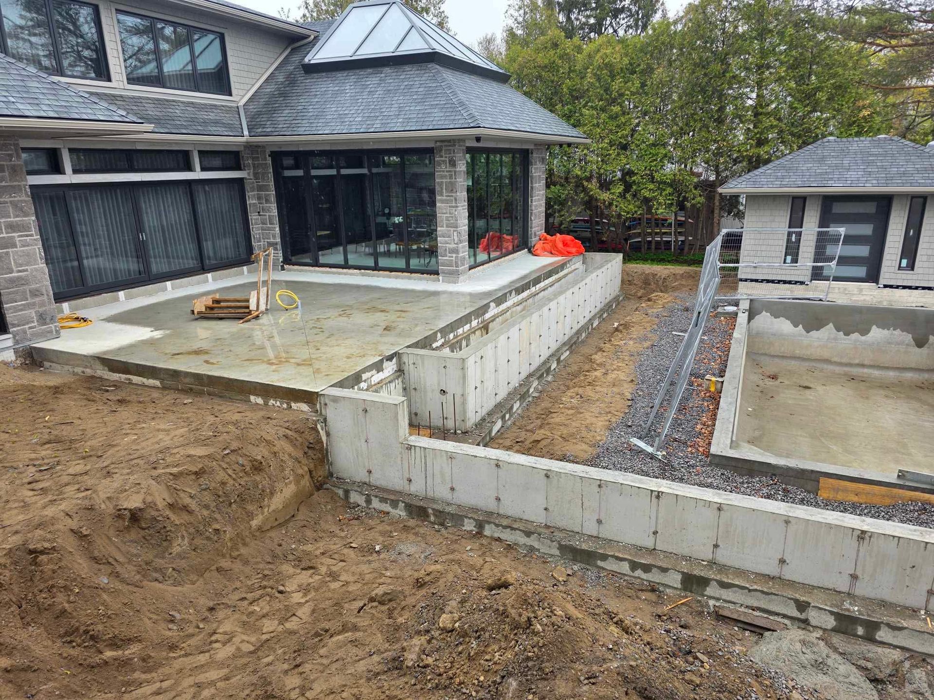 A large house is being built next to a large pool.