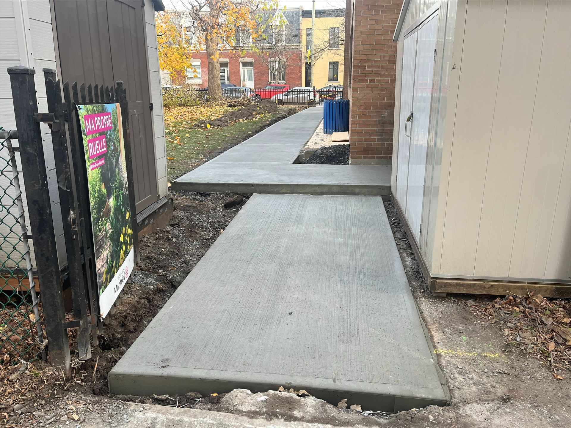 Une passerelle en béton est en cours de construction devant un bâtiment.