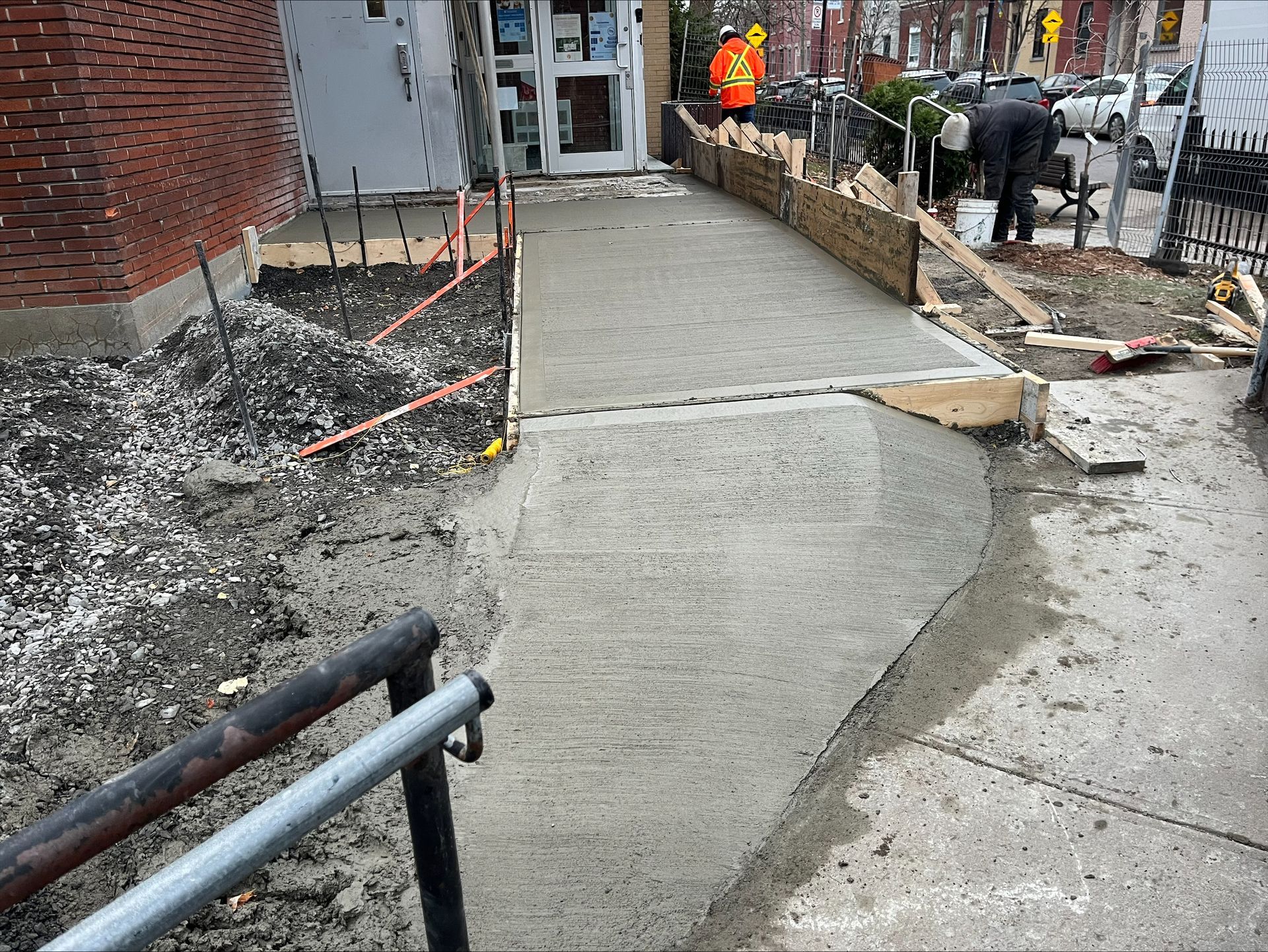 Une passerelle en béton est en cours de construction devant un bâtiment.