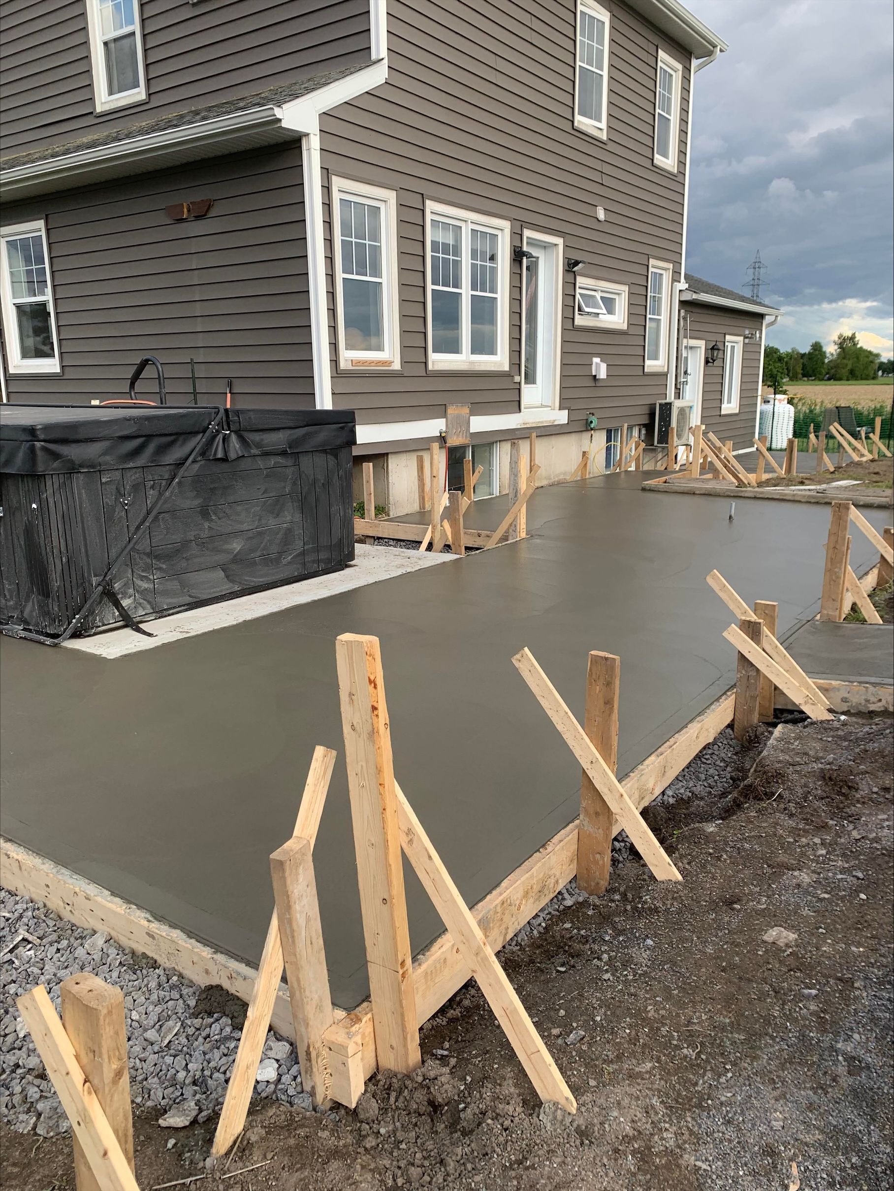Une allée en béton est en cours de construction devant une maison.