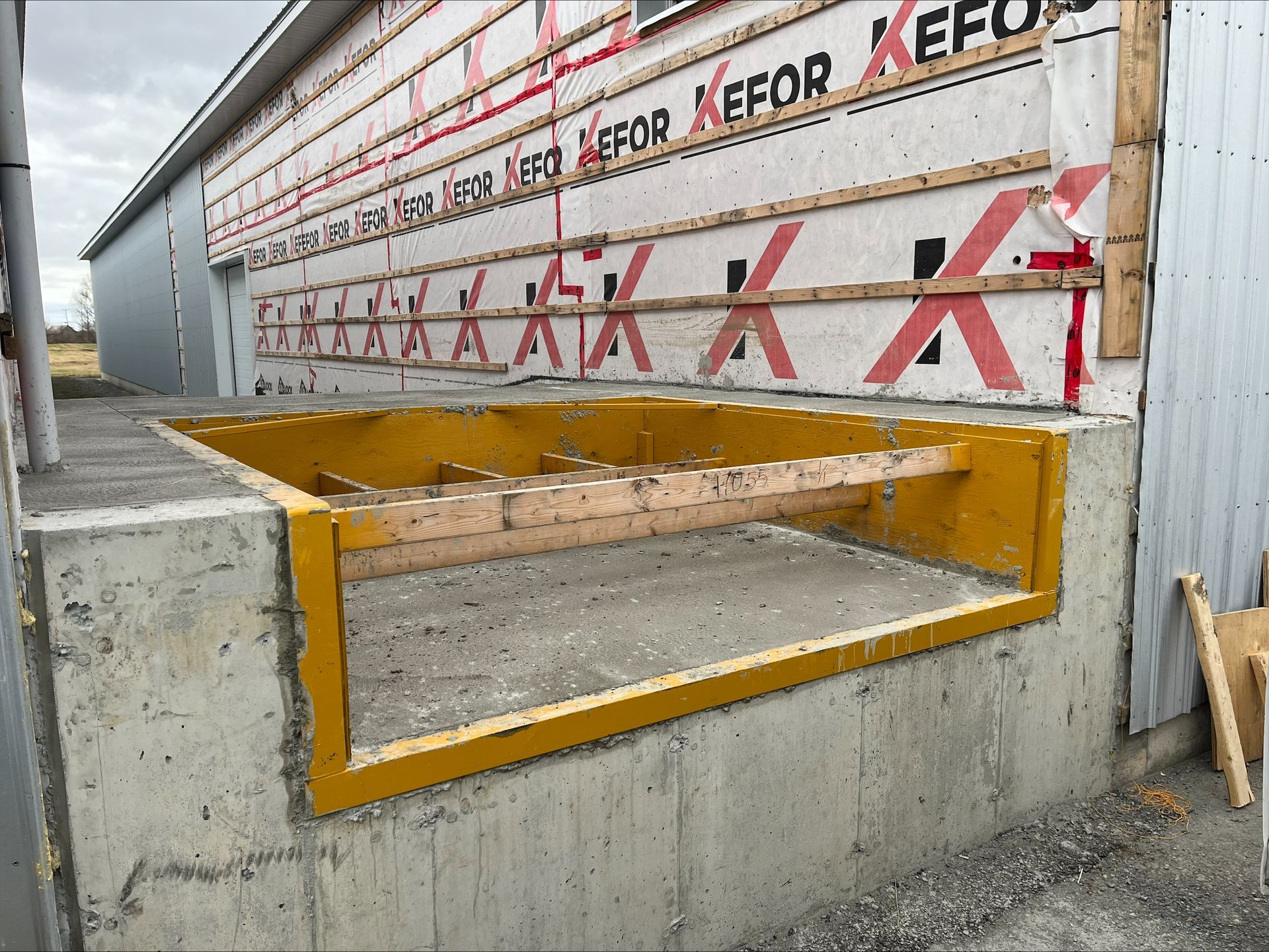 Un mur en béton avec un cadre jaune et le mot « continue » dessus