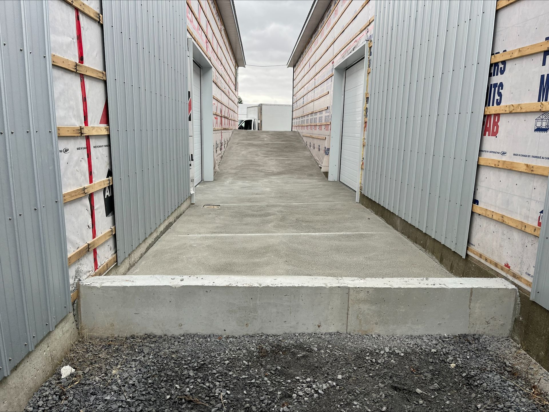 Il y a une passerelle en béton entre deux bâtiments.