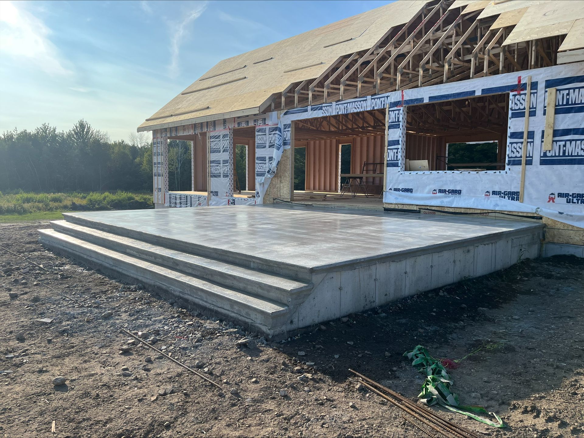 Une maison en construction avec une plateforme en béton et des escaliers.