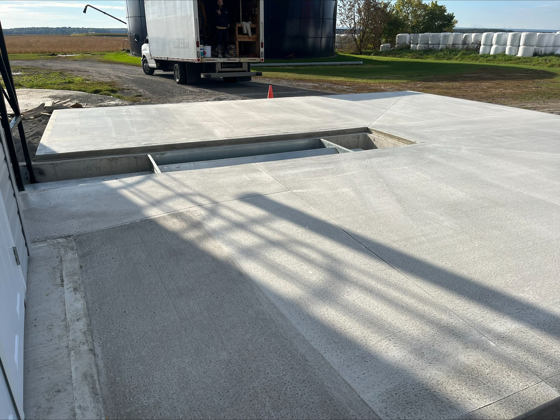 Un sol en béton avec un camion garé en arrière-plan.