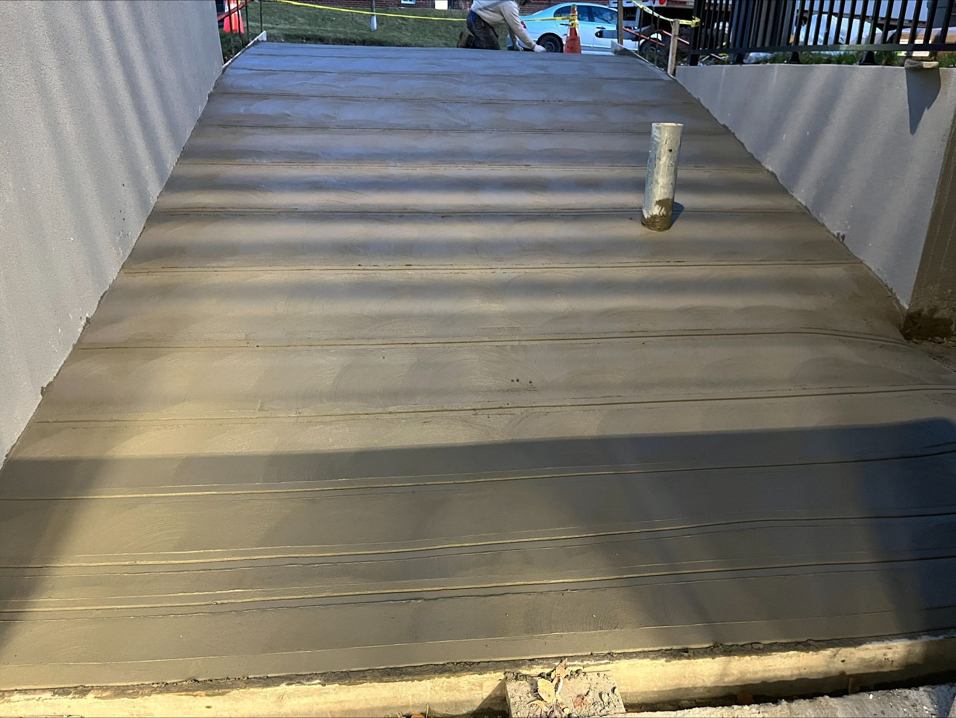 Une passerelle en béton avec un tuyau au-dessus.