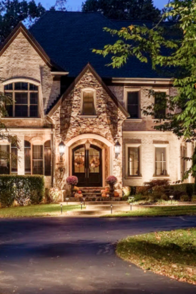 A large house with a blue roof is lit up at night