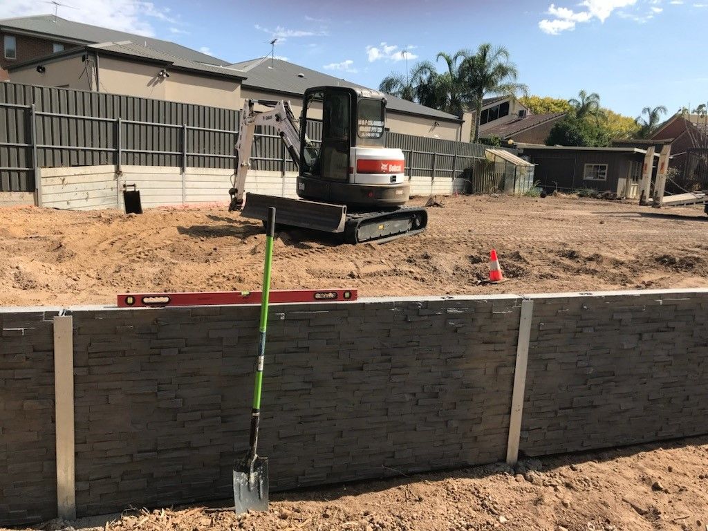 A shovel is sitting next to a bulldozer on a construction site.