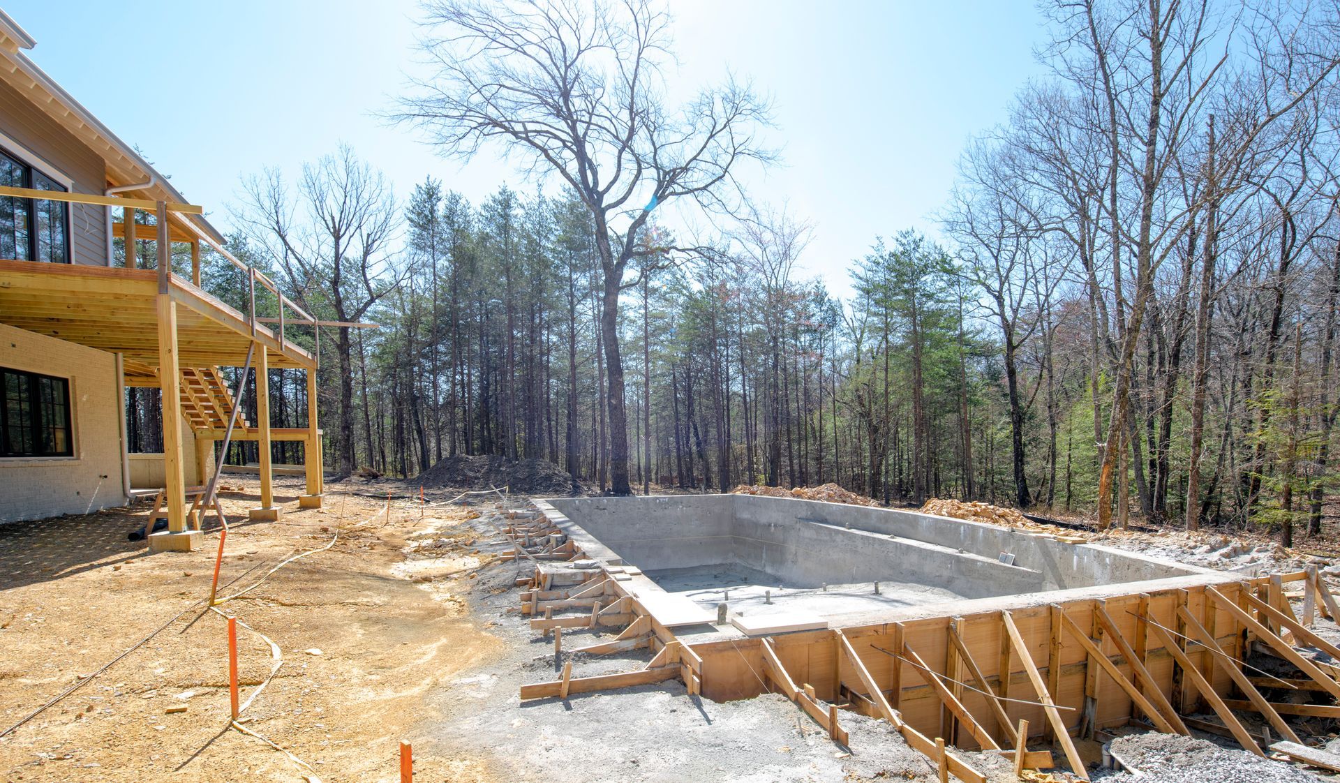 A large swimming pool is being built in the middle of a forest.