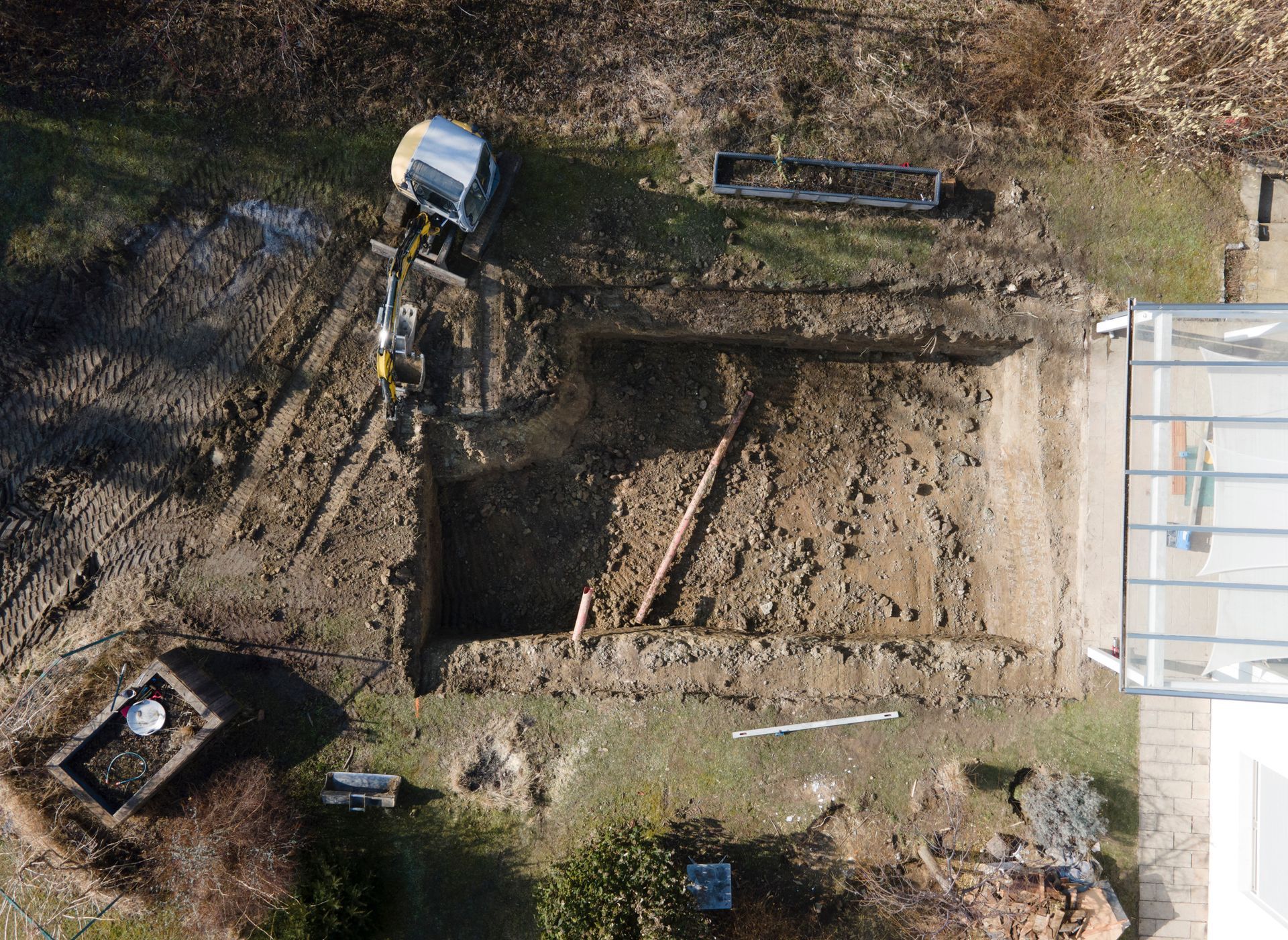 An aerial view of a construction site with a bulldozer digging a hole in the ground.