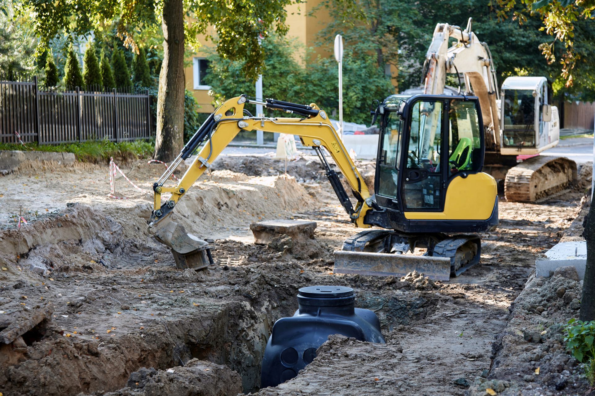 A yellow excavator is digging a hole in the ground.