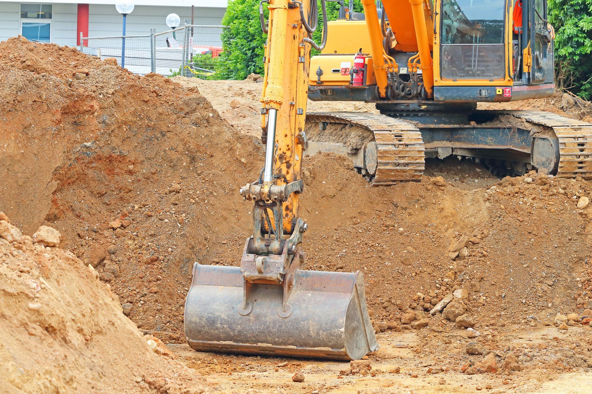 A yellow excavator is digging a hole in the ground.