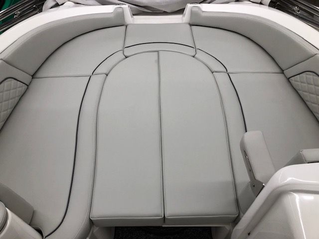 A white boat with a gray cushioned seat