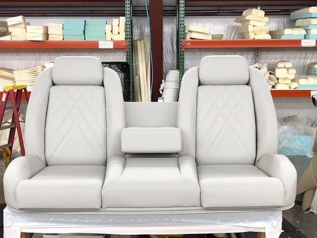 A couch is sitting on top of a wooden table in a warehouse.