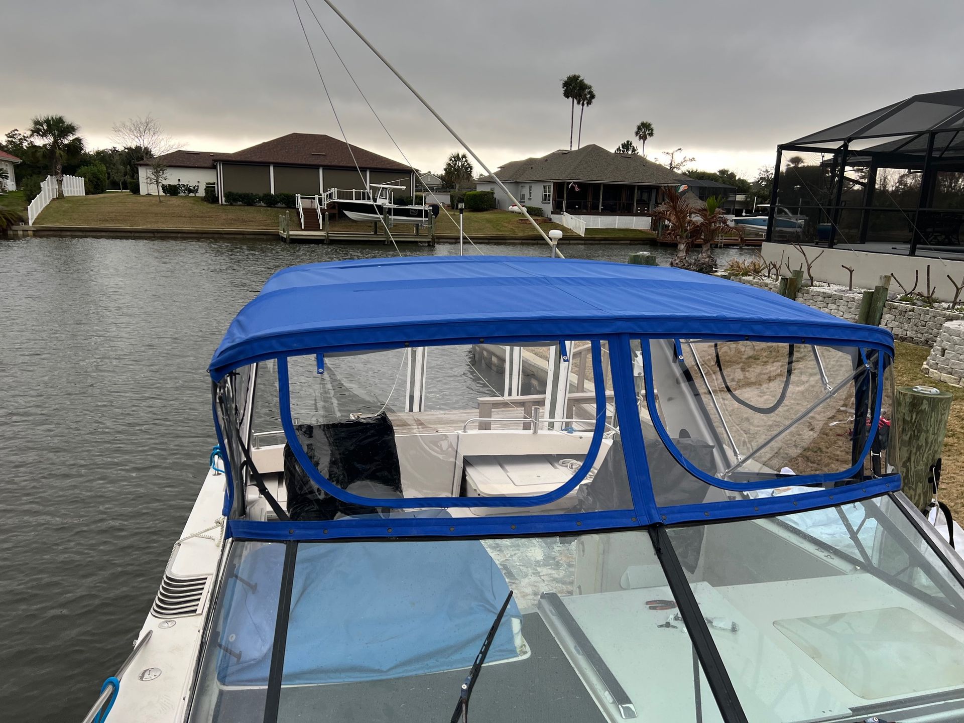 A boat with a blue canopy is floating on top of a body of water.