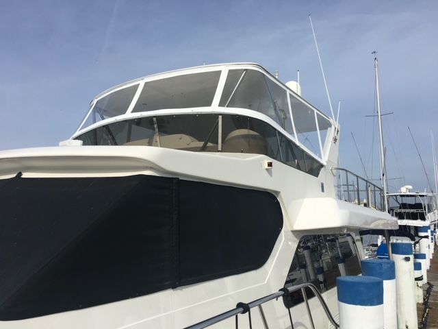 A large white boat is docked at a marina.